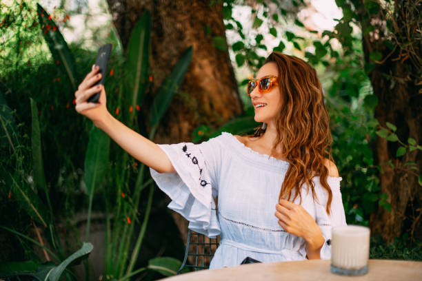 istock Young Woman Making Video Call in Cafe 1387057722