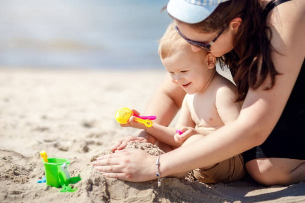 istock Mother and son on the beach playing with sand. 1387058759