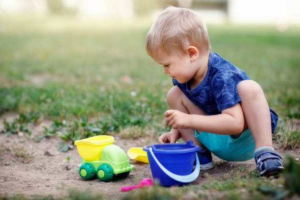istock Boy playing with sand and plastic colorful toys 1387059405