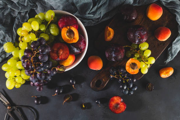 świeżo umyte owoce z kropelkami wody. jasny, wysoki wygląd klawiszy oddaje świeżość. różnorodność świeżych winogron, moreli i pióropuszy na ciemnym tle. źródła owoców witamin - apricot portion antioxidant fruit zdjęcia i obrazy z banku zdjęć