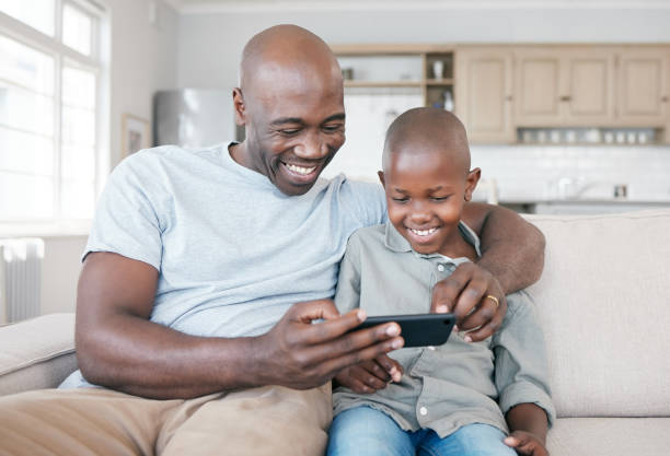 istock Shot of a father and son using a cellphone on the sofa at home 1387062271