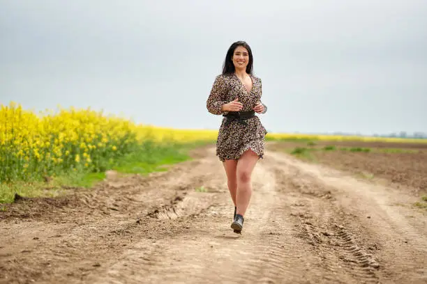 Photo of Plus size woman by a canola field