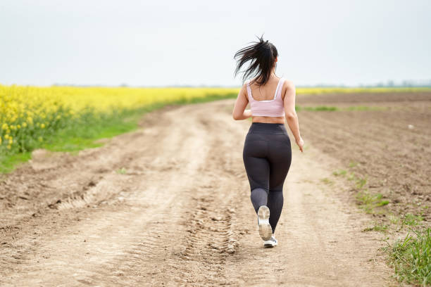 istock Plus size woman running on a countryside dirt road 1387064205