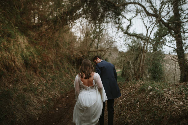 istock Newlywed couple walking in a forest 1387064231