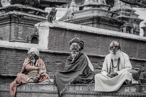 Kathmandu, Nepal- April 20,2019 : Sadhu-Indian Holymen sitting in the temple. In Hinduism, Sadhu is a common term for a mystic, an ascetic, practitioner of yoga. The Sadhu is solely dedicated to achieving the fourth and final Hindu goal of life, moksha (liberation), through meditation and contemplation of Brahman.