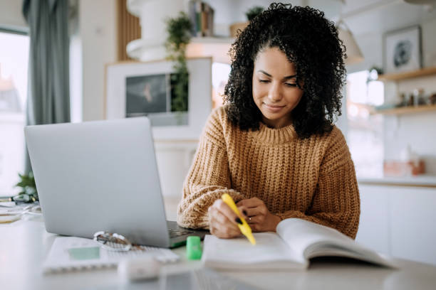 Young beautiful woman studying at home stock photo