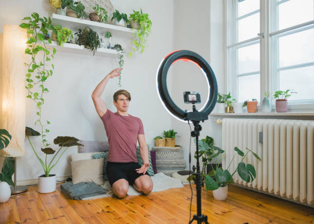 Man teaching yoga on live streaming at home