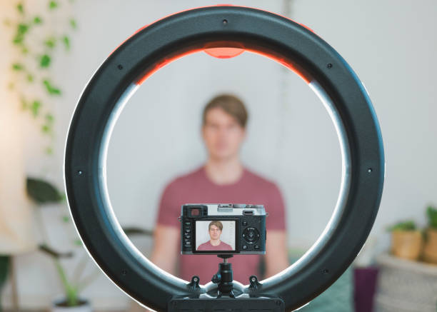 Yoga teacher shoots video for blog with camera and ring light at home stock photo