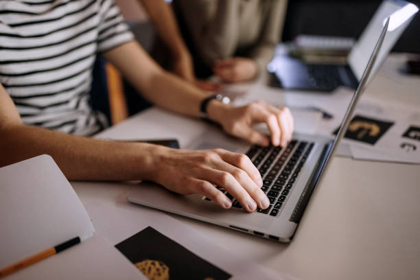 istock Man sitting at desk and working on laptop at night 1387067055