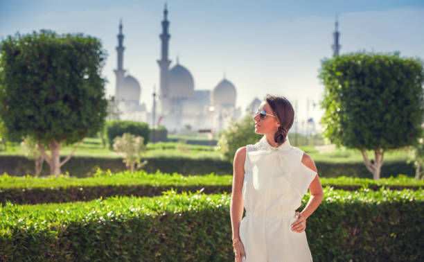 Beautiful Woman in Abu Dhabi Young Woman standing near the Sheikh Zayed Grand Mosque, famous Abu Dhabi sightseeing. Traveling by United Arabic Emirates.  (soft focus) muslim photographer stock pictures, royalty-free photos & images