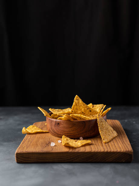 istock Corn Mexican tortilla chips snack on a black dark background. 1387067266