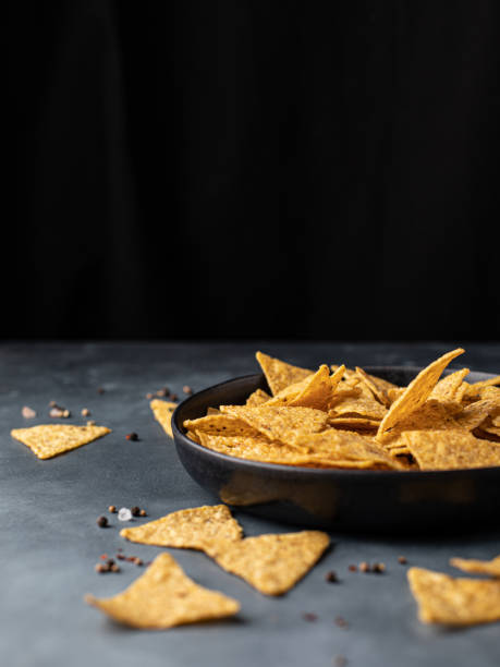 istock Corn Mexican tortilla chips snack on a black dark background. 1387067268