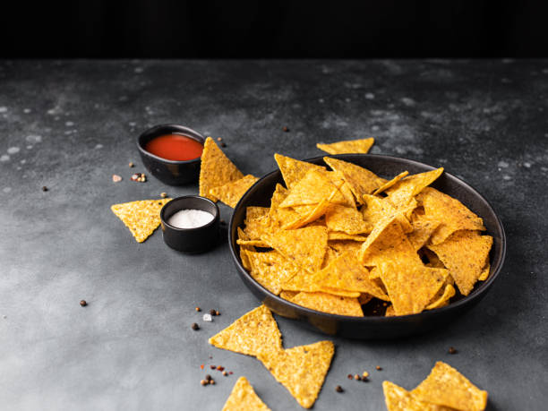 istock Corn Mexican tortilla chips snack on a black dark background. 1387067279