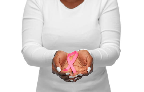 hands of woman with pink cancer awareness ribbon stock photo
