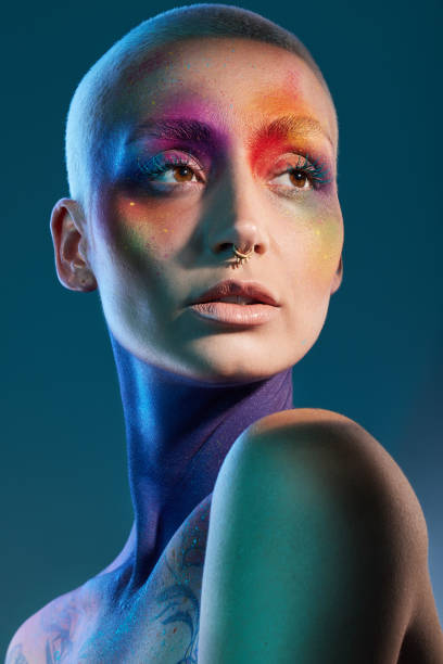 istock Studio shot of a young woman posing with multi-coloured paint on her face 1387069721