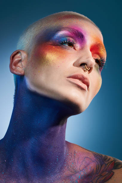 istock Studio shot of a young woman posing with multi-coloured paint on her face 1387069741