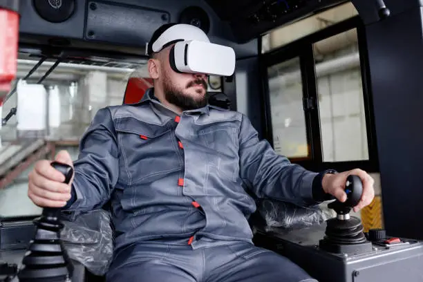 Photo of Confident male builder in vr headset holding by gearshifts while driving machine