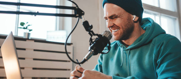 istock Smiling host streaming his live podcast 1387074587