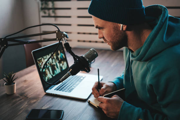 Cheerful host with stubble streaming his audio podcast stock photo