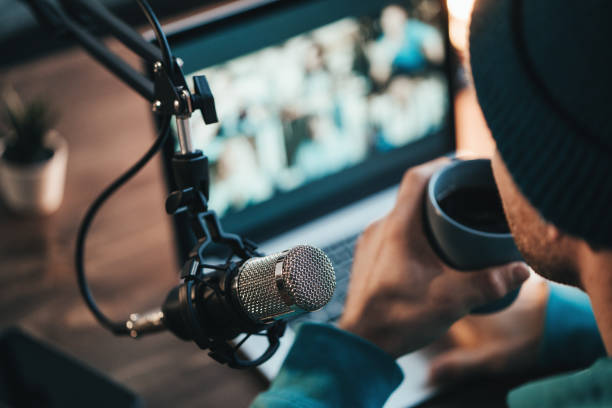 A man host streaming his audio podcast using microphone stock photo