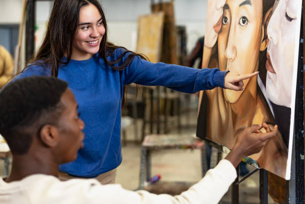 jóvenes estudiantes multirraciales aprendiendo sobre pintura sobre lienzo durante la lección en la facultad de artes de la universidad - concepto de educación y cultura - art university studio domestic room fotografías e imágenes de stock