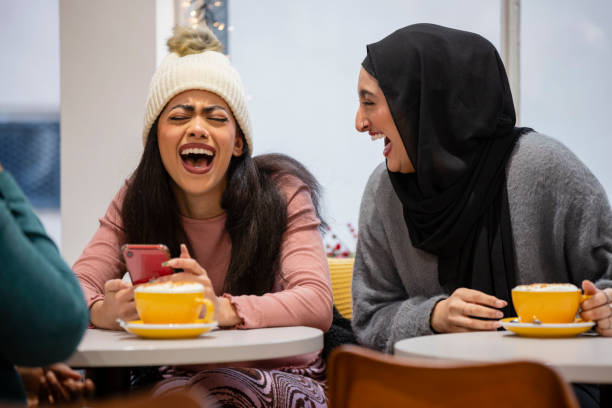amigos riéndose en una cafetería - mobile phone coffee shop group of people women fotografías e imágenes de stock