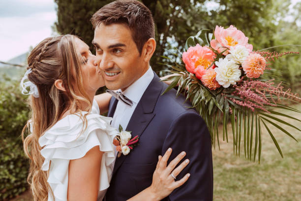 istock Beautiful bride kissing husband during wedding 1387078211