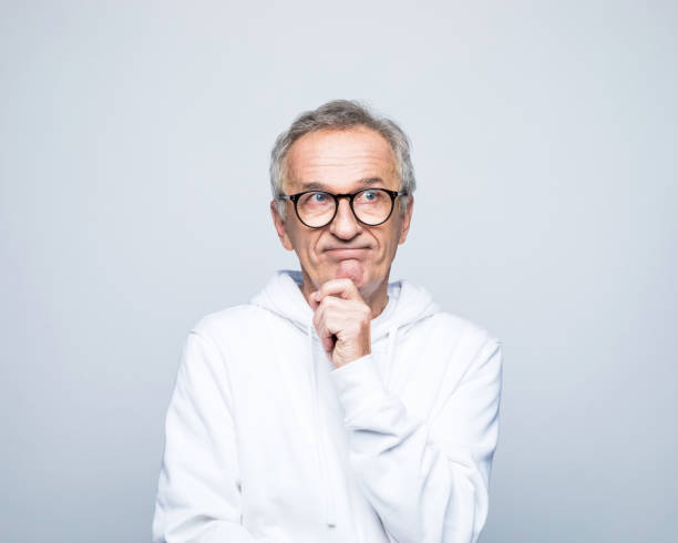 Confused elderly man hand on chin looking away