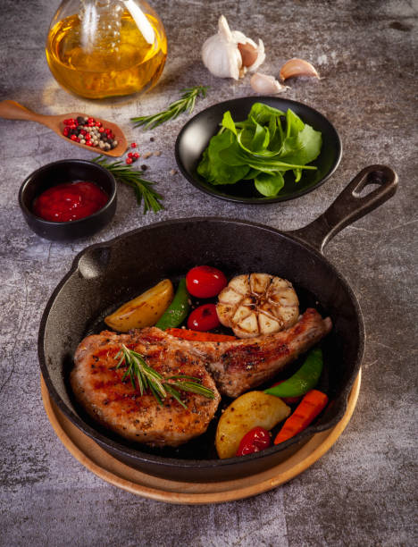 istock Fried pork steak in frying pan, close up view. 1387078459
