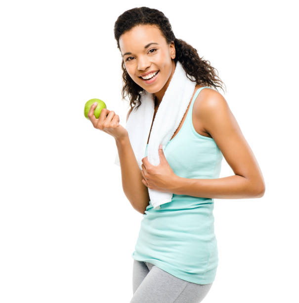 foto de una joven sana a punto de comer una manzana sobre un fondo de estudio - apple healthy eating eating black fotografías e imágenes de stock