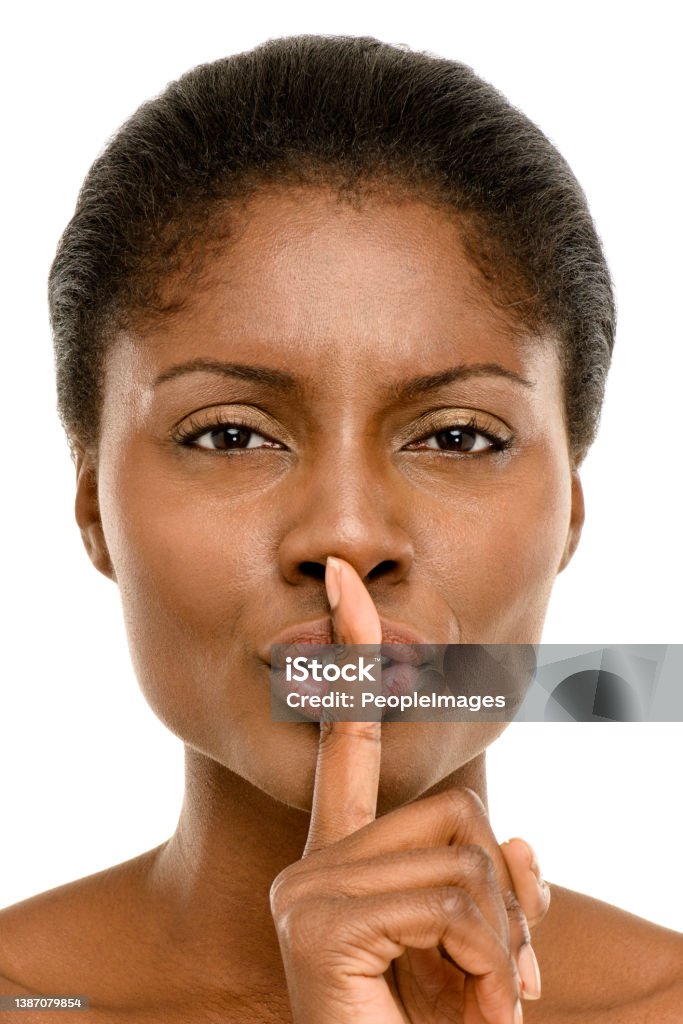 Studio shot of a young woman placing her finger on her lips against a white studio background Not everything is for everyone 20-24 Years Stock Photo