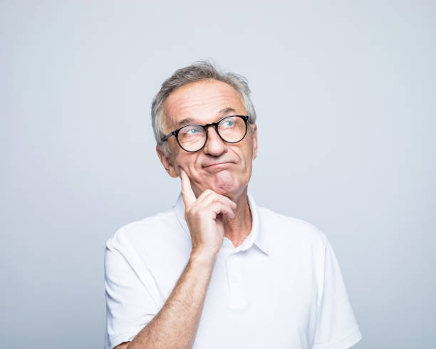 istock Thoughtful senior man with hand on chin looking away 1387080214