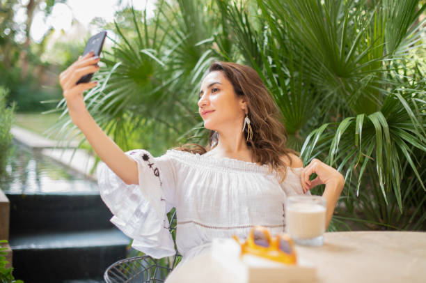 istock Young Woman Taking Selfie in Cafe 1387080240