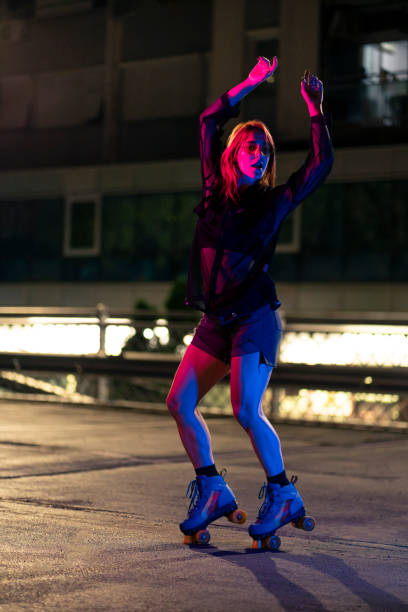 istock Beautiful young female roller skater dancing 1387081666