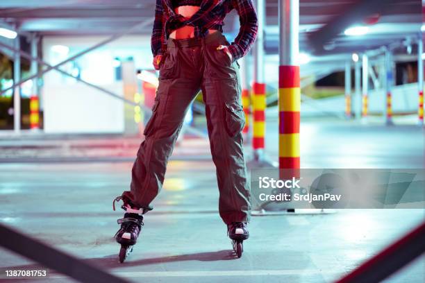 Unrecognized Person In Roller Skates Standing In The Parking Lot Of A Public Garage Stock Photo - Download Image Now