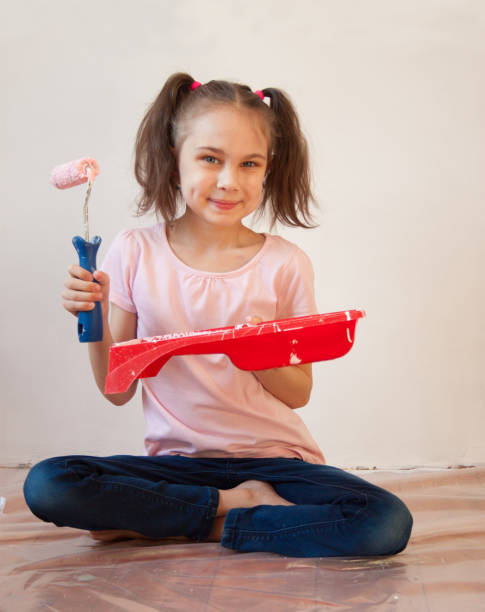 istock A girl with a paint roller in his hands 1387081958