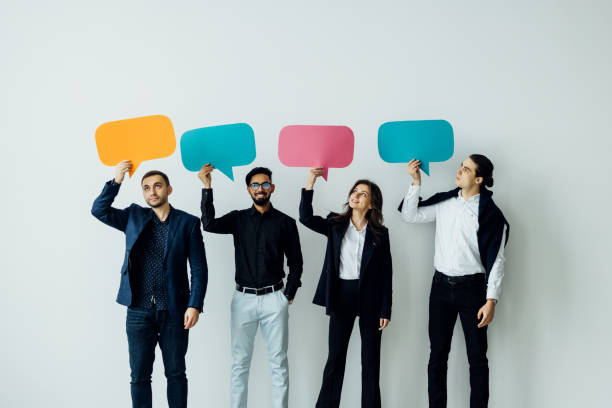 istock Beautiful young people are holding speech bubbles, looking at camera and smiling, on white background 1387084794