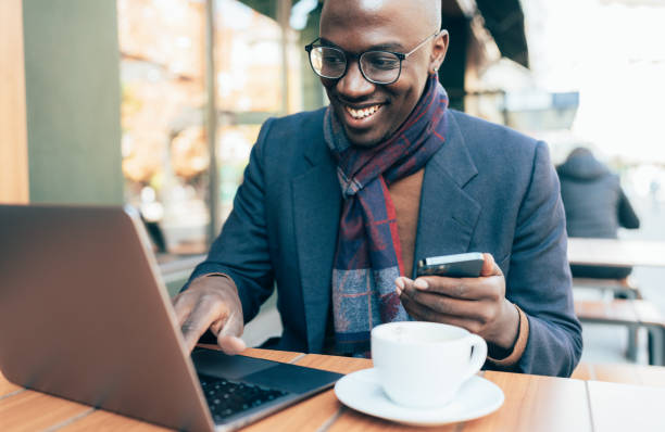 istock Young man sitting in coffee shop and using laptop 1387085824