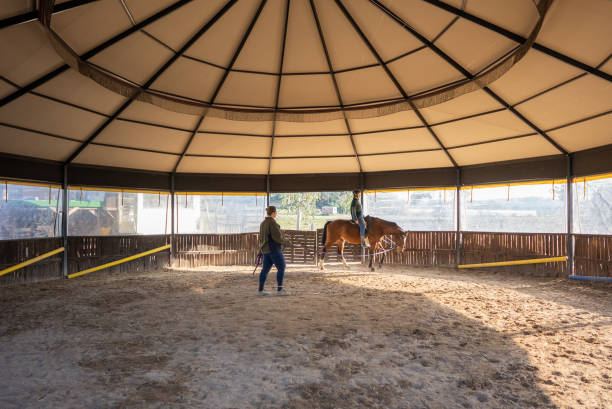 istock Female riding teacher coaching her student. 1387085864