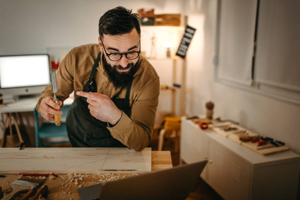 istock Bearded artist adjusting tripod on workbench in art studio 1387090834