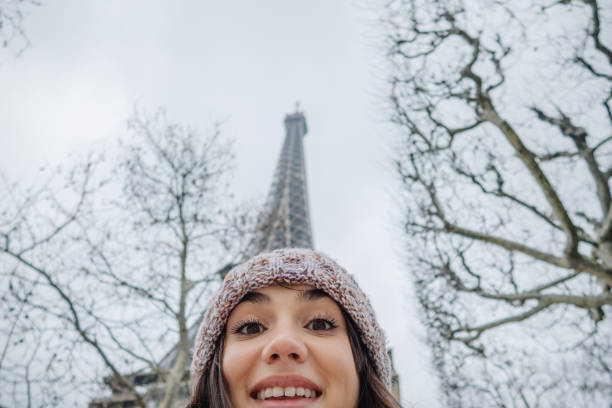 Eiffel tower and Christmas decoration. Selective focus on red balls. Black white red aged photo.