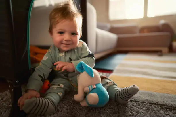 Photo of Cute baby boy playing with toys home and looking at camera
