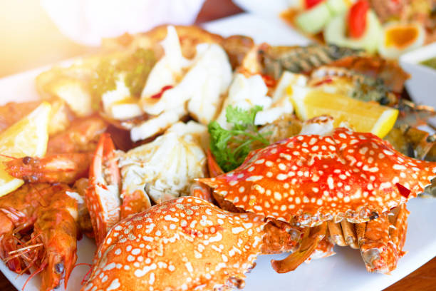 Sea food on big plate include shrimps ,lemon,squid and crab shell