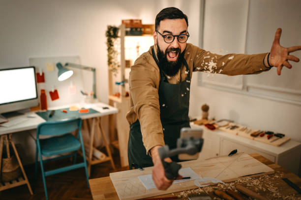 istock Bearded artist throwing sawdust while vlogging in art studio 1387095237