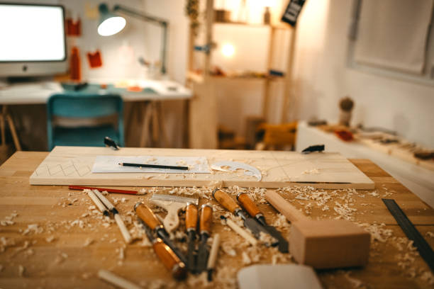 Close-up of wood with paper and pencil by various hand tools on workbench in art studio