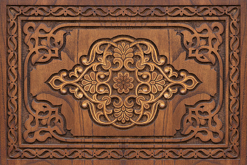 Antique decorated mettallic keyhole on a wooden door.