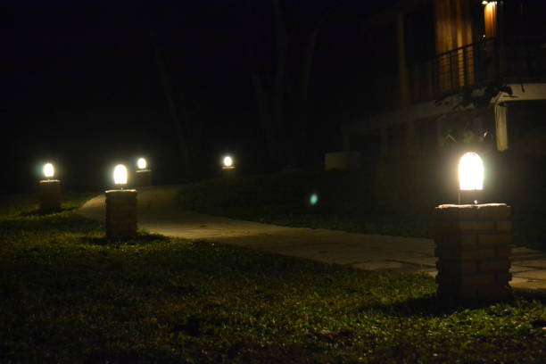 istock Lamplight illuminating along with walking path at night 1387096683