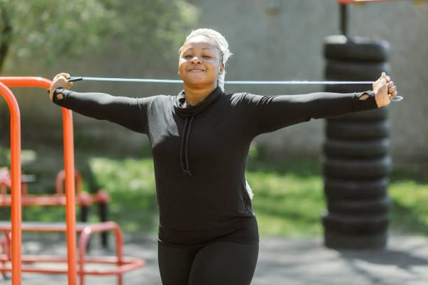 istock Afro-american plus size woman doing workout exercises session outdoor 1387096784