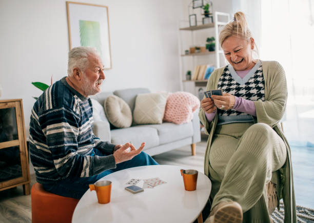 istock senior friends having fun while playing cards 1387099445