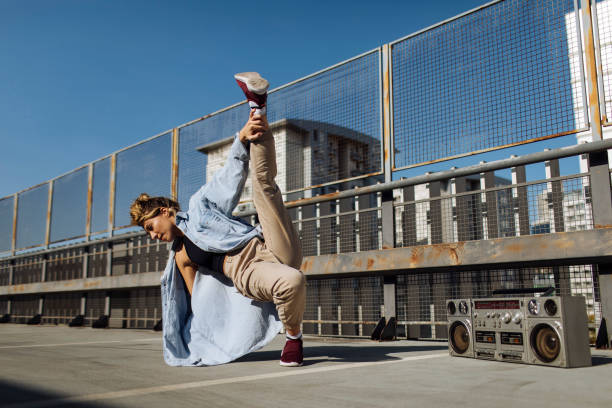 Hip-hop girl doing breakdance move on roof terrace
